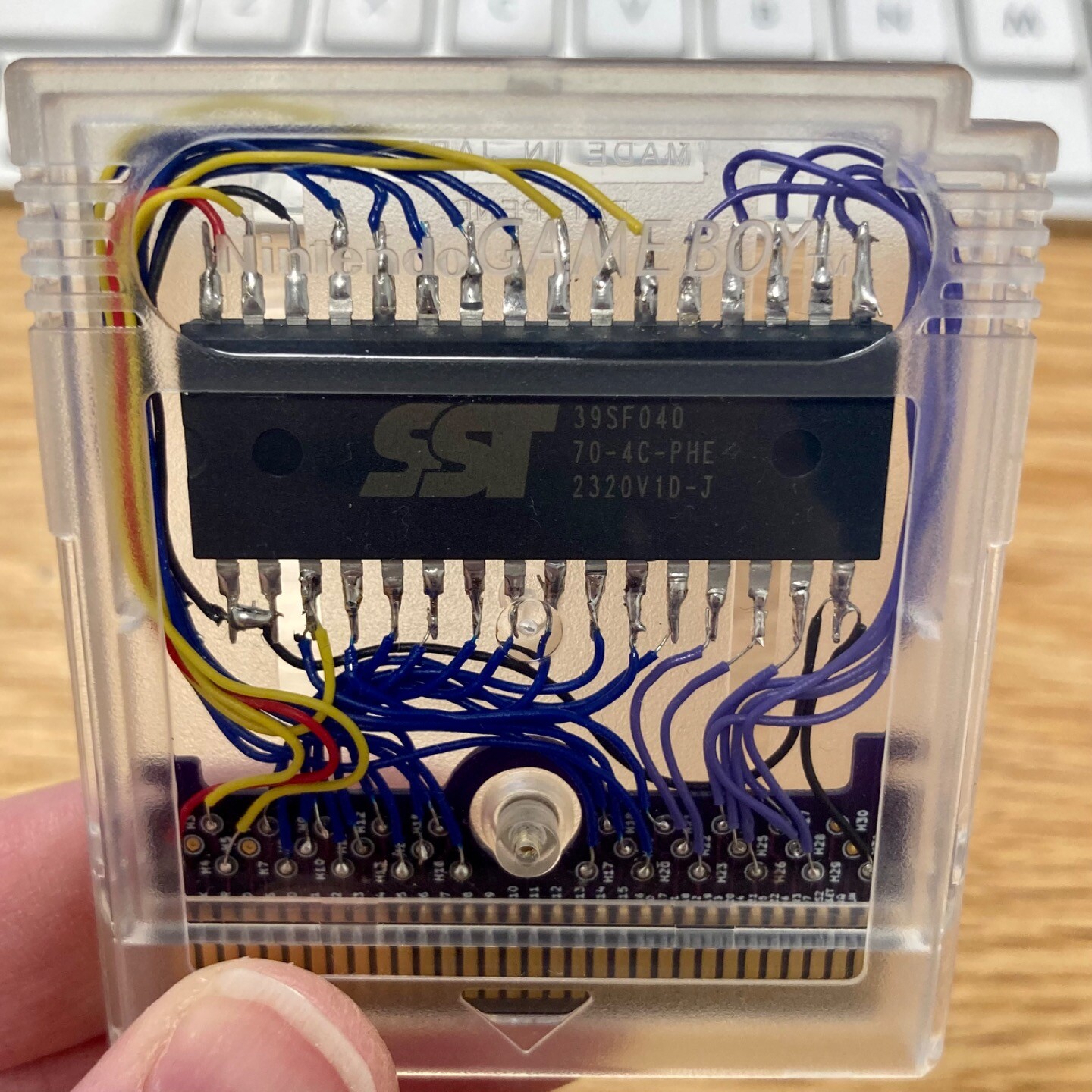 Game Boy cartridge with the legs of a DIP parallel flash IC soldered to a cartridge edge breakout