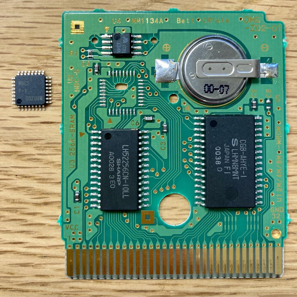 A cartridge next to its MBC5 chip, which I desoldered specifically to create images with visual interest for this document